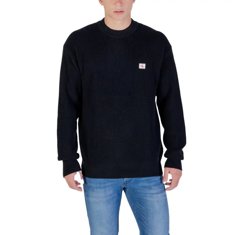 Calvin Klein Jeans black cotton ribbed knit sweater with small red and white logo patch on left chest