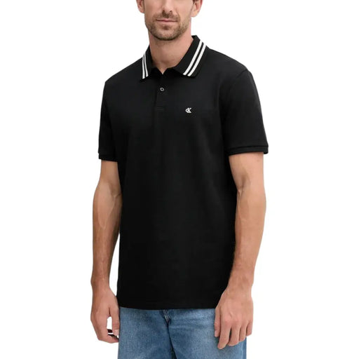 Black polo shirt with white trim and logo, made of cotton.