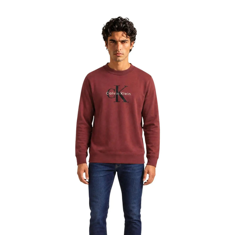 Calvin Klein Jeans Pull en coton bordeaux pour homme, orné du logo CK noir entrelacé et du nom de la marque (vue de face).
