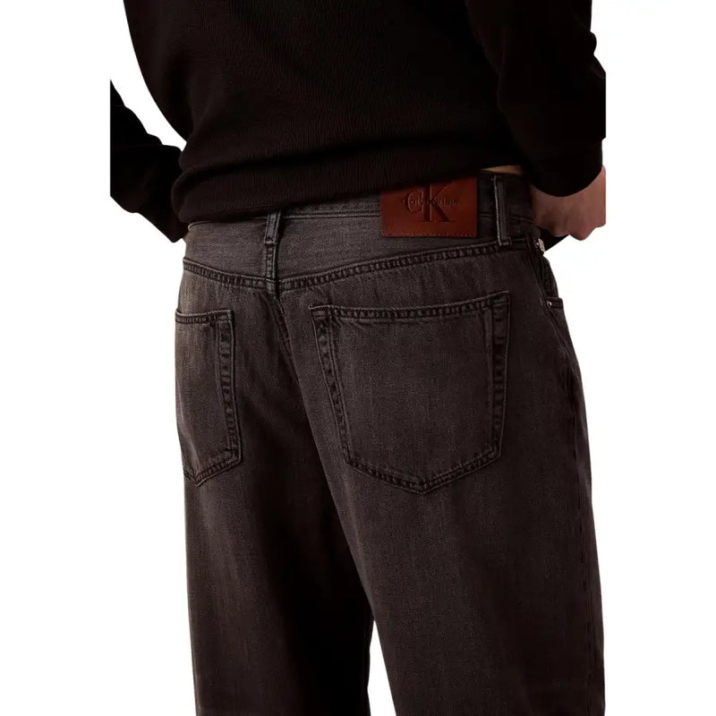 Dark gray Calvin Klein jeans back side showing classic pocket design and brown leather brand patch in lyocell viscose