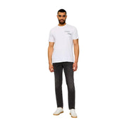 White calvin klein t-shirt with subtle black cursive logo paired with beige cotton classic fit jeans for men