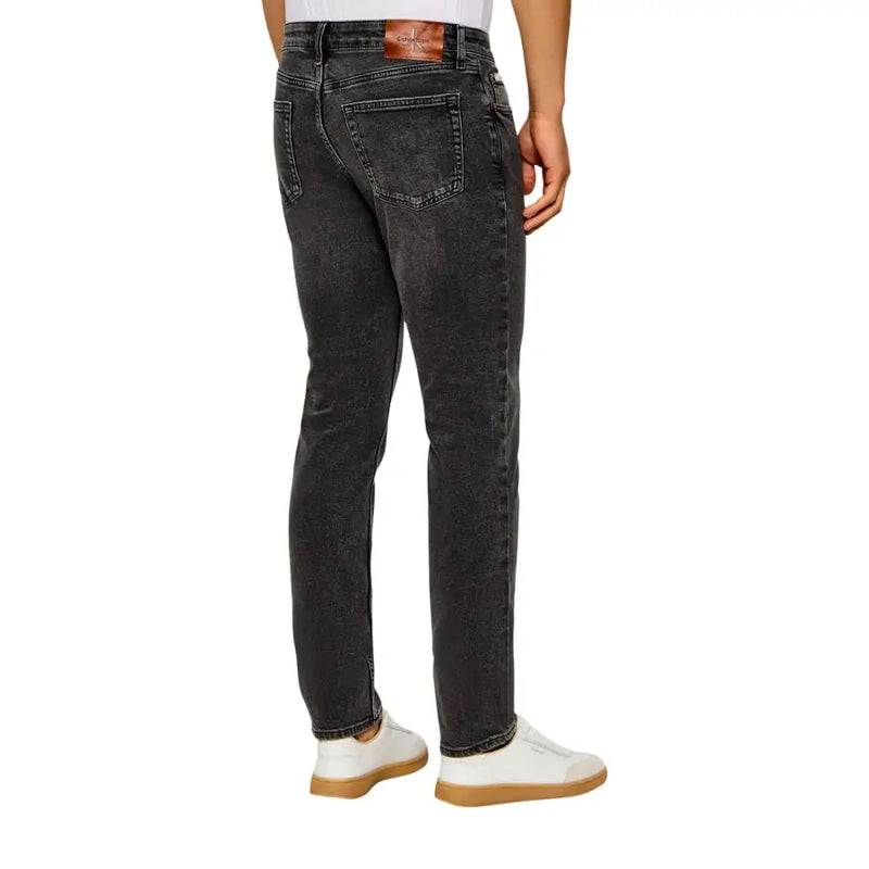 Calvin Klein jeans men dark gray denim jeans with faded distressed finish and brown leather brand patch at waistband