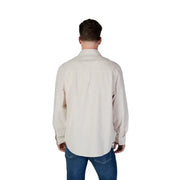 Men’s beige cotton long-sleeved button-down shirt paired with blue jeans in Calvin Klein Jeans collection