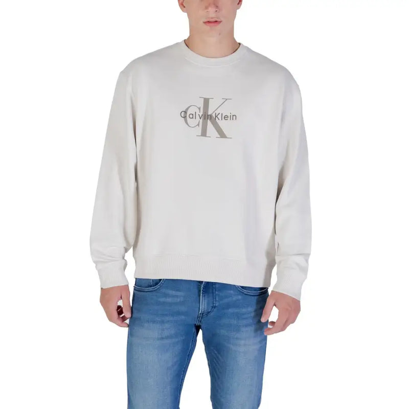 Men’s beige Calvin Klein crewneck sweatshirt paired with blue jeans for casual style