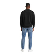 Schwarzes Baumwoll-Sweatshirt mit Rundhalsausschnitt und langen Ärmeln, kombiniert mit hellblauen Jeans von Calvin Klein Jeans Männer