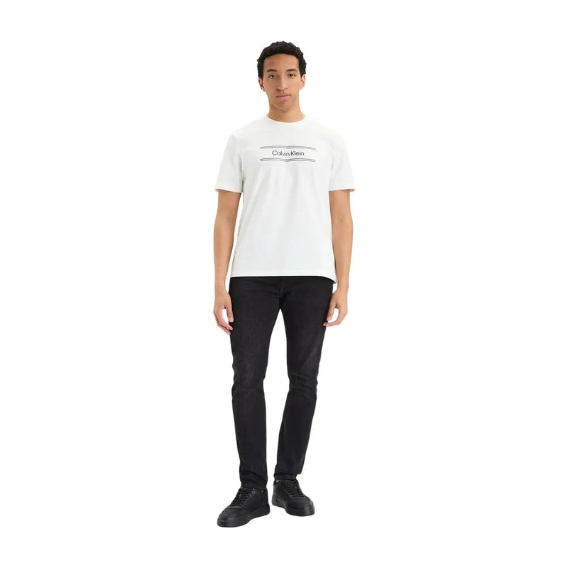 White calvin klein t-shirt with black logo and horizontal lines paired with black cotton denim slim jeans for men