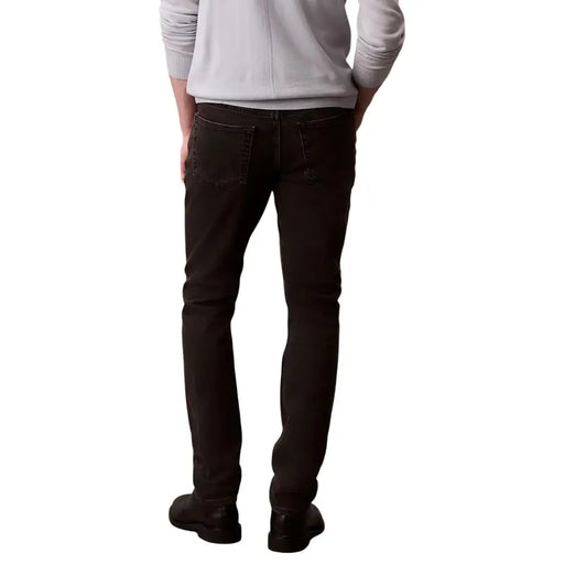 Calvin klein jeans men black cotton stretch dark wash slim fit denim jeans showing the back side with classic pockets