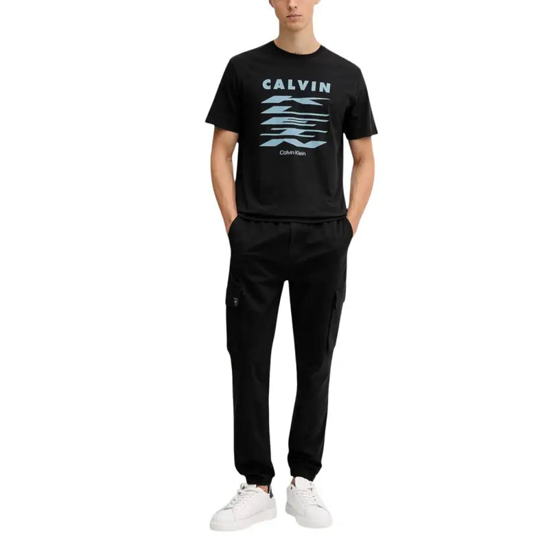 Black calvin klein t-shirt with light blue stacked kleen logo paired with black fall winter cotton blend trousers