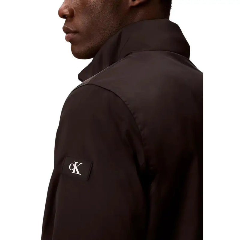 Calvin Klein Jeans Schwarzer Herrenblazer mit Reißverschluss aus Polyester mit dezentem Glanz und kontrastierendem weißen Logo-Patch auf der linken Brust