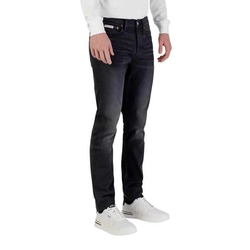 Calvin Klein Jeans Jean slim noir en denim de coton pour homme, légèrement délavé, fermeture éclair et bouton.