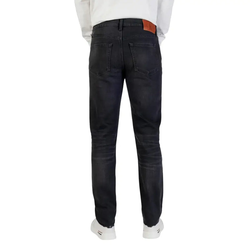 Coupe slim délavée foncée Calvin Klein Jean en coton pour homme avec fermeture éclair noire et étiquette de marque en cuir marron à la ceinture