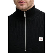 Calvin Klein Jeans Schwarzer Herren-Strickpullover aus Baumwolle mit halbem Reißverschluss in Silber und weißem Logo-Patch auf der Brust