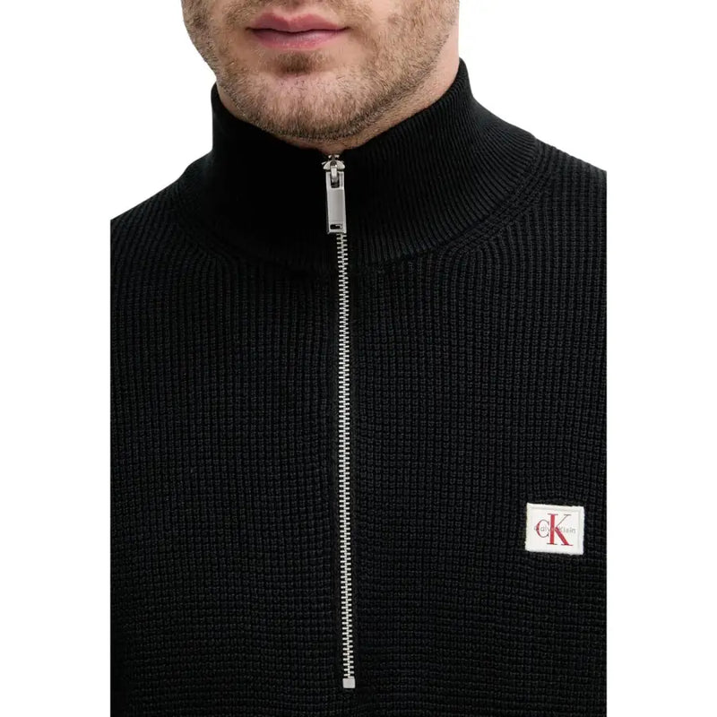 Calvin Klein Jeans Schwarzer Herren-Strickpullover aus Baumwolle mit halbem Reißverschluss in Silber und weißem Logo-Patch auf der Brust