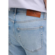 Back view of calvin klein jeans men blue cotton denim jeans with light wash and brown leather brand patch on waistband