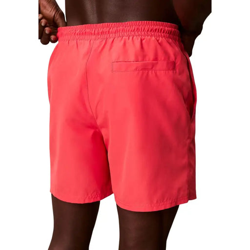 Calvin Klein Jeans men coral swim shorts polyester with elastic waistband and single back pocket shown from the back side