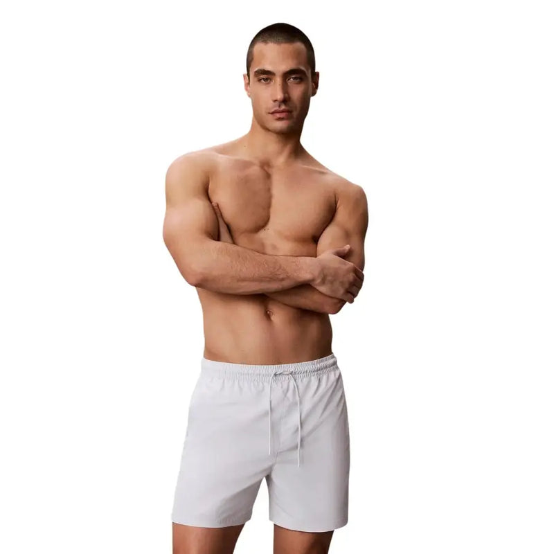 Calvin Klein Jeans Graue Herren-Badehose mit Kordelzug, mittelgroß, abgebildet als weiße Sportshorts mit elastischem Bund und Kordelzug