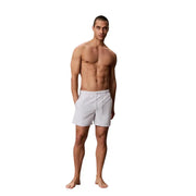 Calvin Klein Jeans Graue Herren-Badehose mit Kordelzug, Größe M, dargestellt als weiße Sportshorts mit Kordelzugbund