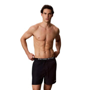 Black calvin klein swim trunks with white logo band and drawstring waistband made of polyester medium size