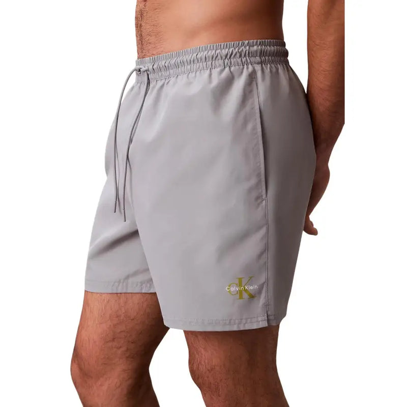 Calvin Klein Jeans men grey polyester swim shorts medium with subtle gold logo on lower leg for swimming