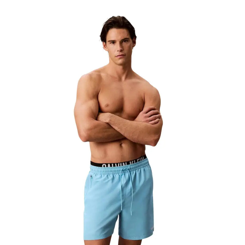 Light blue calvin klein swim trunks with black waistband and drawstring made of polyester for men medium size