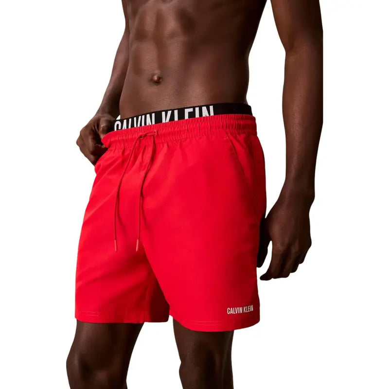 Calvin Klein bright red polyester swim trunks with black waistband and white branding for men medium size
