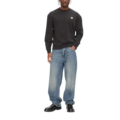 Calvin Klein Jeans men round neck black cotton sweatshirt with long sleeves and a small white logo on the chest