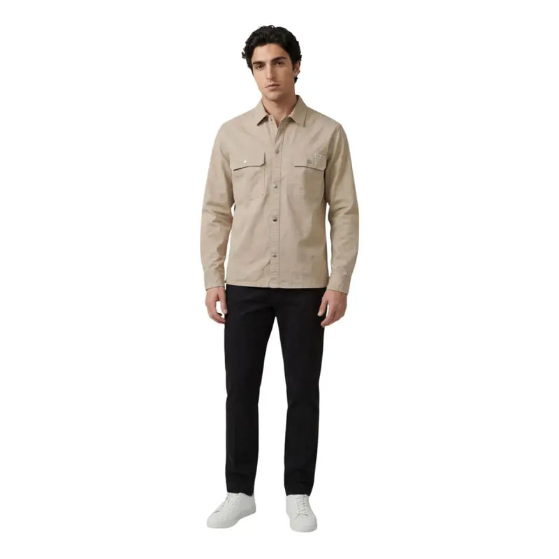 Beige Calvin Klein Jeans Herren-Langarmhemd mit Knopfleiste, zwei Brusttaschen und dezentem Logo auf der linken Tasche.
