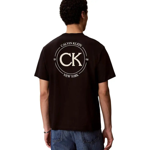 Schwarz Calvin Klein Jeans Herren-T-Shirt aus Baumwolle mit auffälligem, weißem, kreisförmigem CK-Logo und Calvin Klein New Yorker Text von 1968
