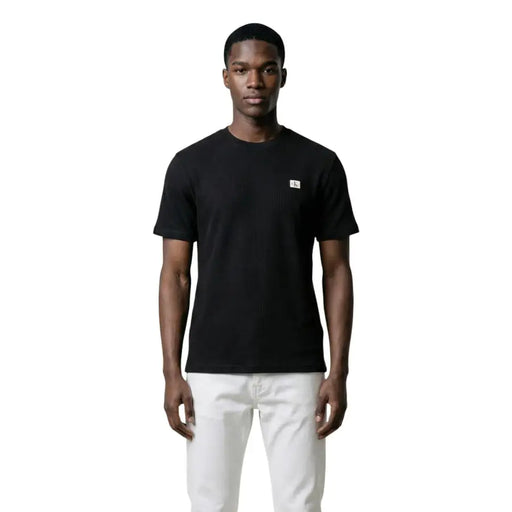 Black Calvin Klein Jeans men t-shirt with small white logo on left chest, made from soft cotton fabric