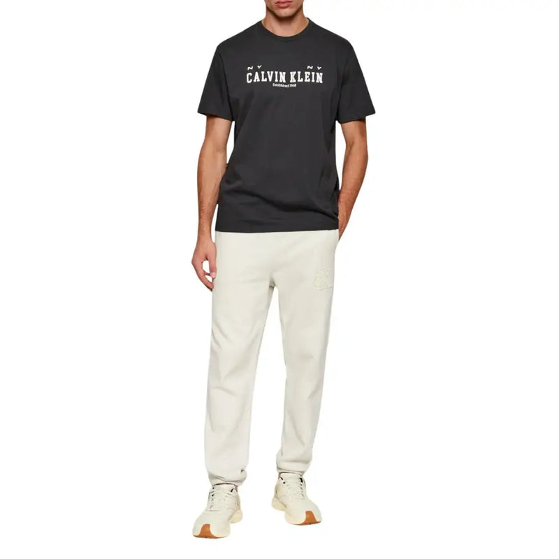 Black Calvin Klein Jeans men t-shirt with white ny Calvin Klein logo and founded 1969 text on cotton fabric