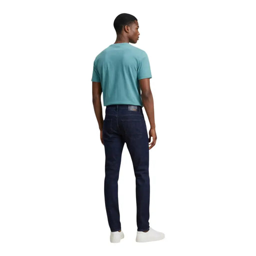 Calvin klein jeans mens t-shirt paired with dark blue slim fit denim jeans featuring subtle stitching details