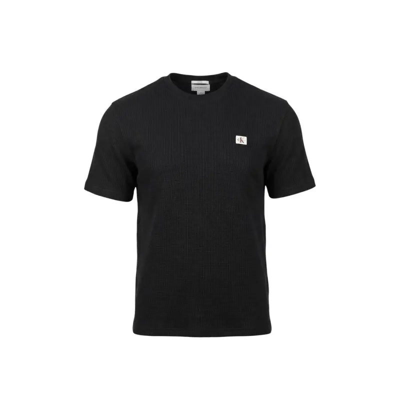 Schwarz Calvin Klein Jeans Männer t-shirt mit gerippter Textur und kleinem weißen Logo-Aufnäher auf der linken Brust