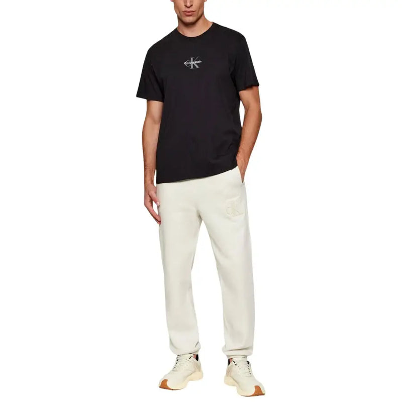 Noir Calvin Klein Jeans hommes t-shirt avec logo blanc sur la poitrine, confectionné dans un tissu en coton confortable