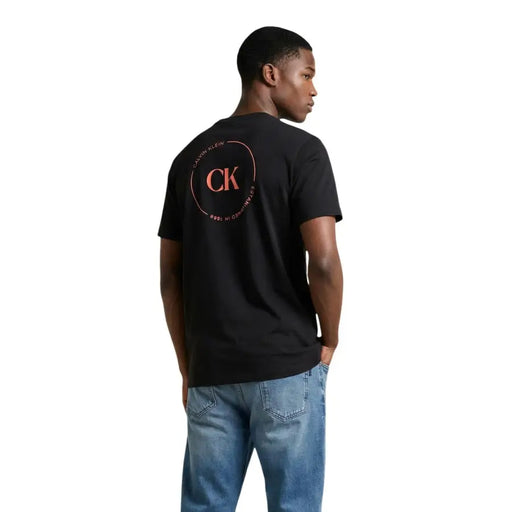 Black Calvin Klein Jeans men t-shirt featuring a circular pink CK logo with initials on the front