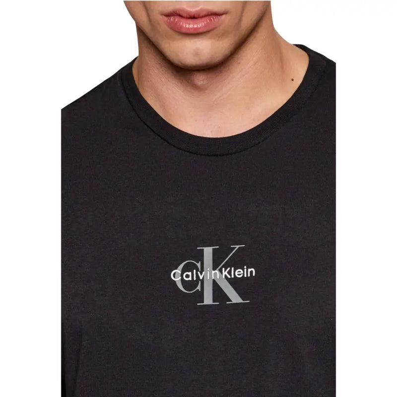Calvin Klein Jeans hommes t-shirt en noir avec un discret logo CK argenté et le nom de la marque centrés sur la poitrine