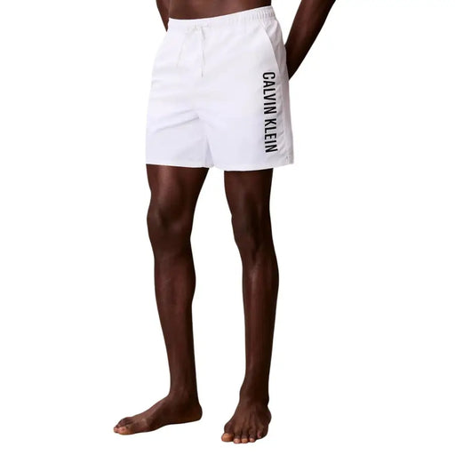 White calvin klein jeans men’s polyester swim trunks with black vertical branding on the side for swimwear use