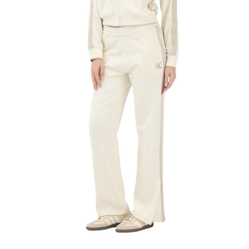 Calvin Klein Jeans women beige cotton trousers featuring cream-colored track pants with side slit and embroidered logo