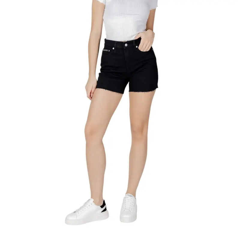 Black high-waisted cotton denim shorts with frayed hem and subtle brand logo on the back waistband by Calvin Klein Jeans