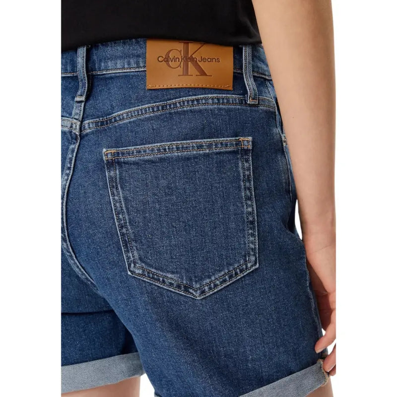 Dark blue cotton denim shorts for women with rolled cuffs and a brown leather calvin klein patch on the back waistband