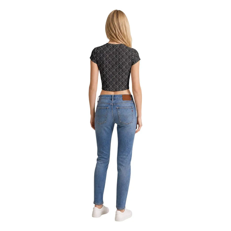 A pair of light-wash blue skinny jeans with brown leather belt loops shown with calvin klein jeans women grey cotton round neck t shirt