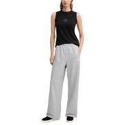 Black sleeveless calvin klein top with subtle embroidered logo paired with grey cotton trousers with pockets