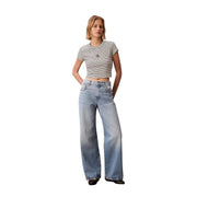 A pair of light-wash wide-leg denim jeans with classic five-pocket design paired with calvin klein jeans women striped round neck black top