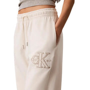 Cream-colored calvin klein women white cotton sweatpants with textured embroidered logo and lace details on the thigh