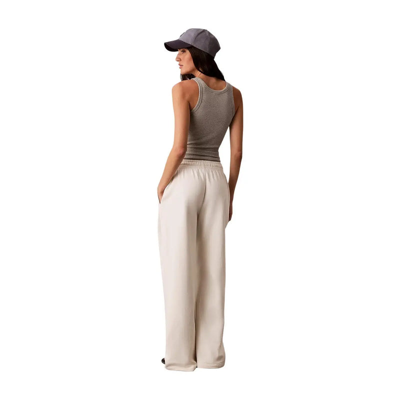 Calvin Klein Jeans women white cotton trousers with laces feature wide-leg cream satin fabric and an elastic waistband