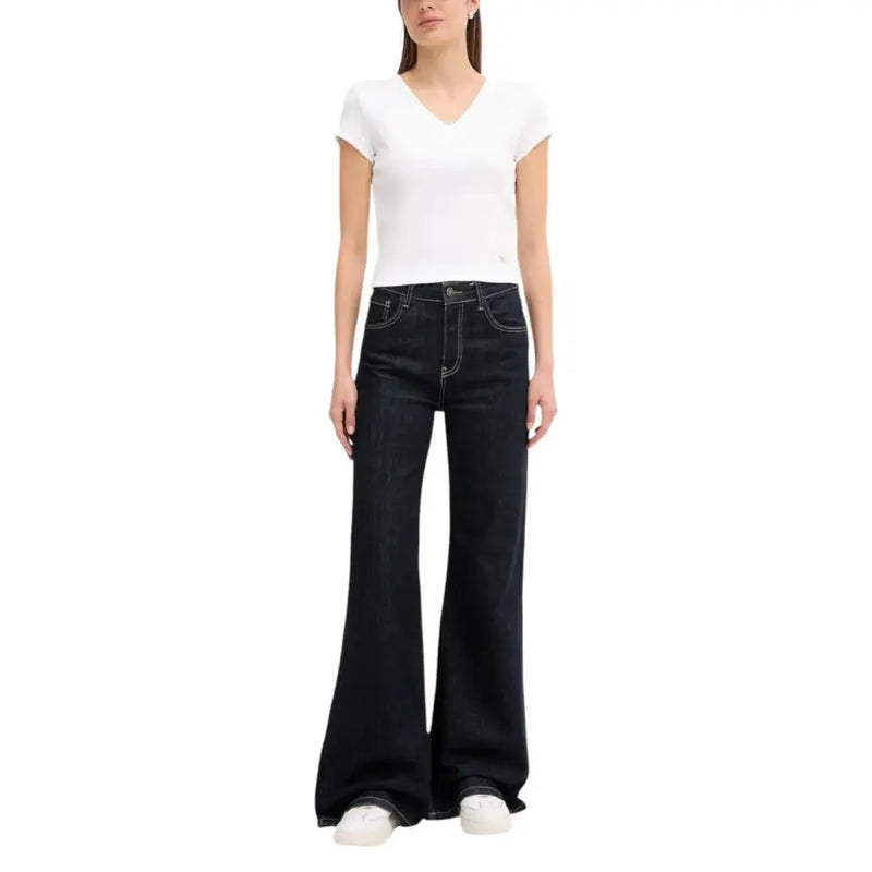 Calvin klein jeans women white v neck short sleeve t shirt paired with dark wash denim flare jeans with white stitching and five pockets