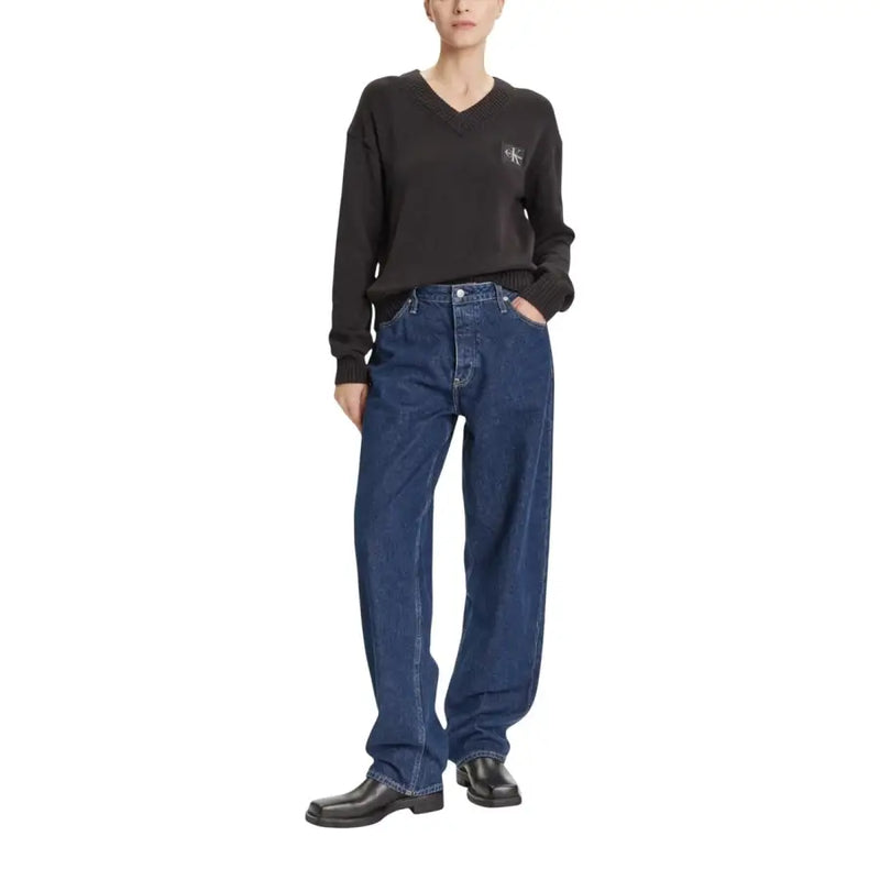 Woman wearing Calvin Klein Jeans black cotton V-neck long knitwear with dark blue jeans