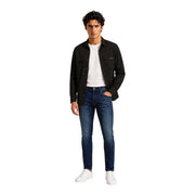 Schwarzes, langes Herrenhemd von Calvin Klein aus Baumwollmischgewebe, kombiniert mit dunkelblauen, schmal geschnittenen Jeans mit dezenten Auswaschungen an den Knien.