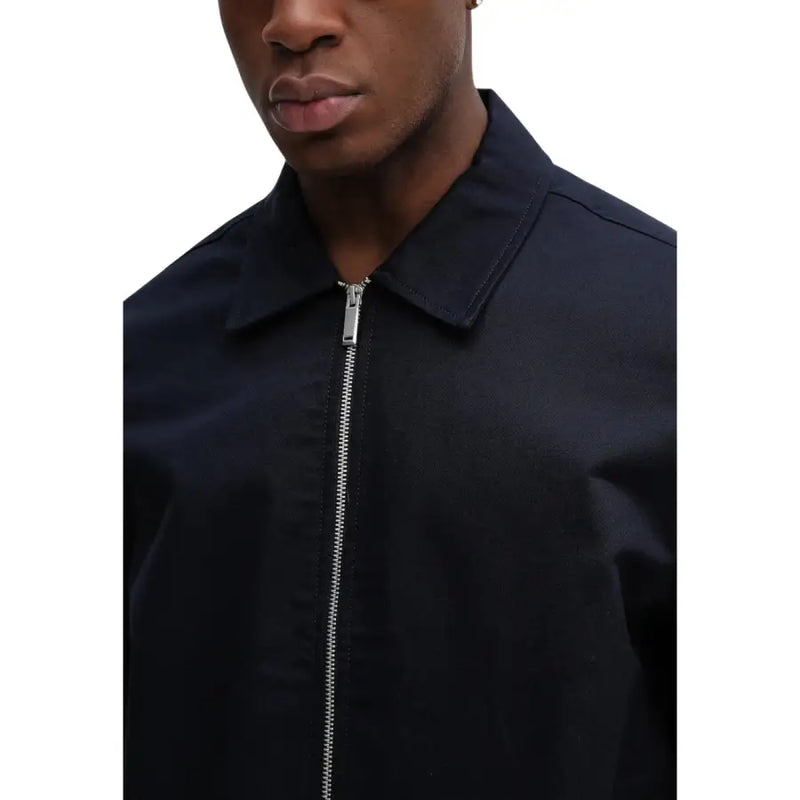 Blazer Calvin Klein pour homme, bleu coton, coupe classique, col structuré et fermeture éclair argentée.