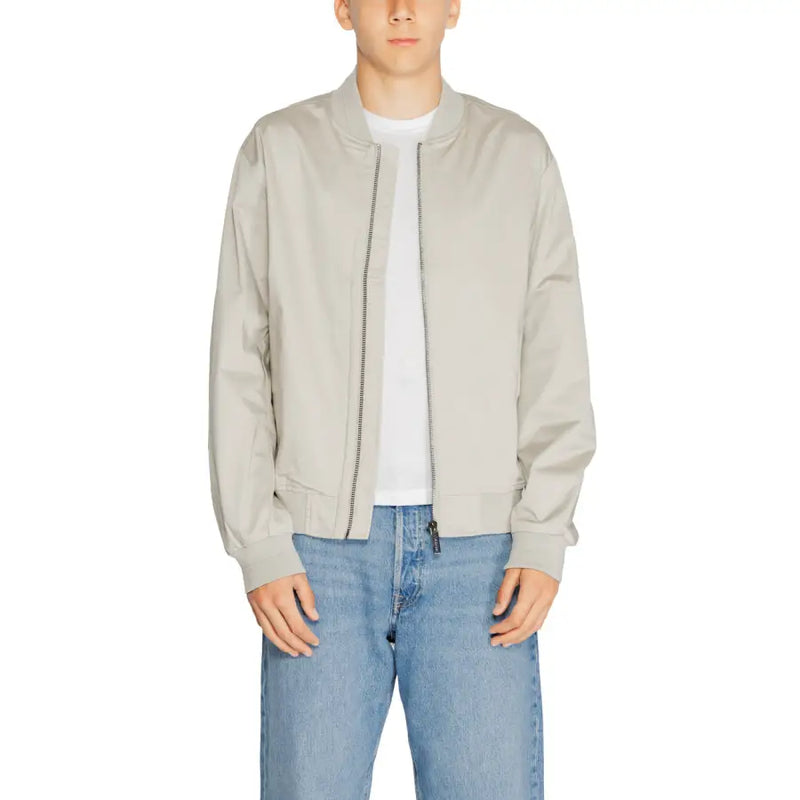 Men’s light grey bomber jacket with white t-shirt and blue jeans displayed in Calvin Klein product