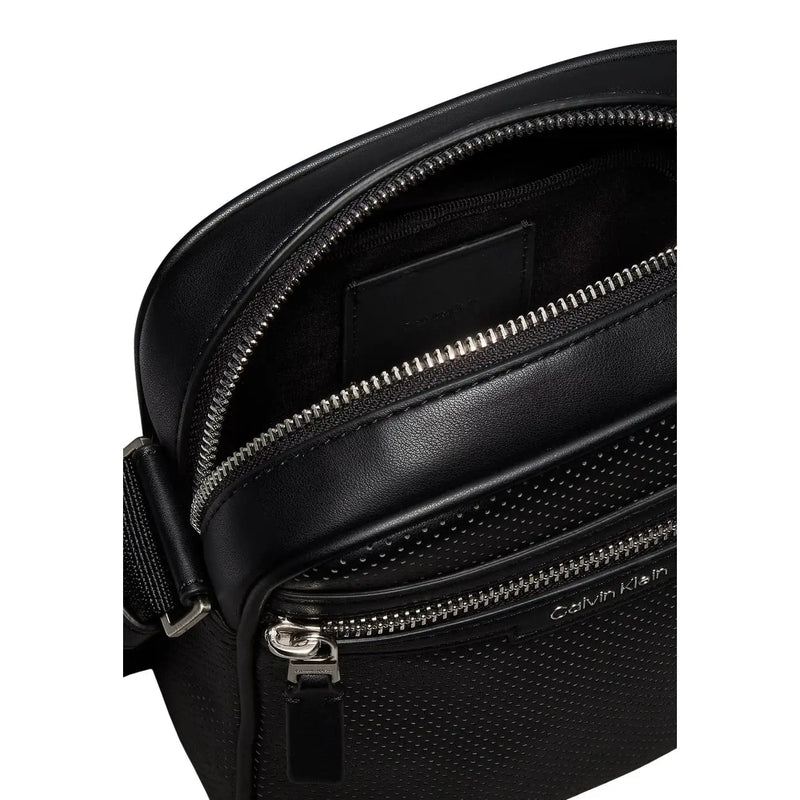 Black leather Calvin Klein men perforated reporter bag with silver zippers and textured surface in size W6 H21 L6